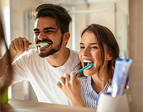 Couple brushing teeth to prevent toothaches in Randolph