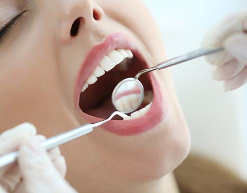 Close up of dentist examining woman’s mouth