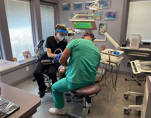 Dentist and dental team member treating dentistry patient