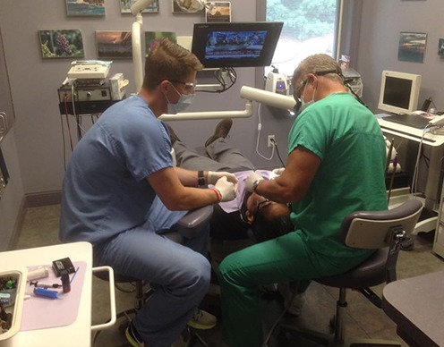 Doctors Glen and Zachary Goldstein treating dental patient