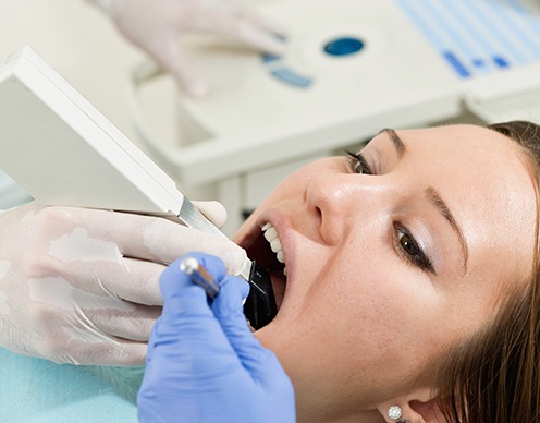 Dentist capturing shade of patient's tooth using digital hand tool