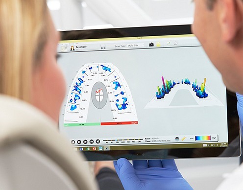 Dentist and patient looking at bite recording analysis