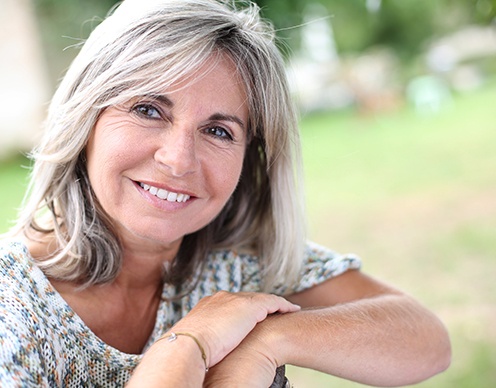 Woman smiling after teeth tomorrow tooth replacement