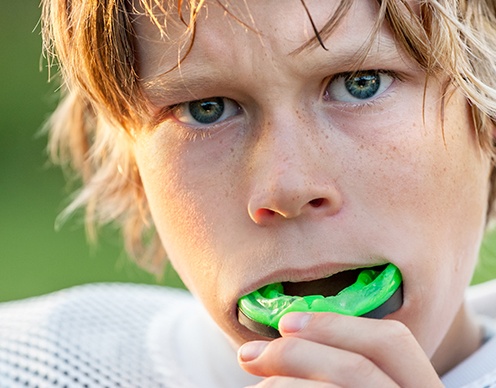 Teen boy placing athletic mouthguard