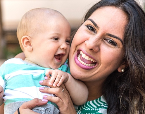 Mother holding baby after lip and tongue tie treatment