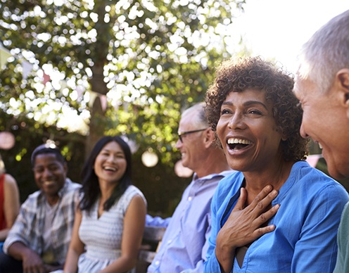 Diverse group of friends with dental implants in Randolph laughing together outside