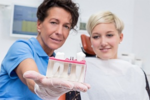Randolph implant dentist showing patient model of dental implants 