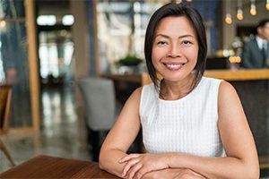 Young woman in a café with dental implants in Randolph