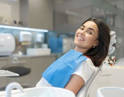 Smiling dental patient reclining in treatment chair