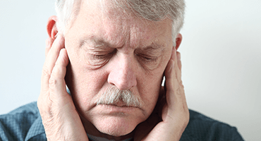 Man in need of T M J therapy holding jaw joints