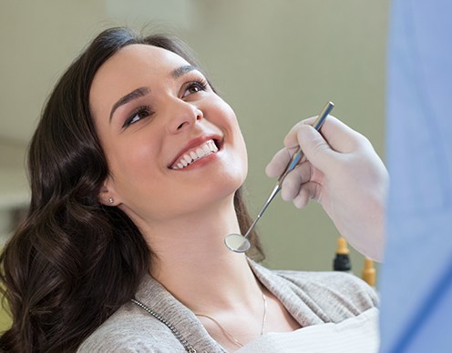 Woman smiling during preventive dentistry exam