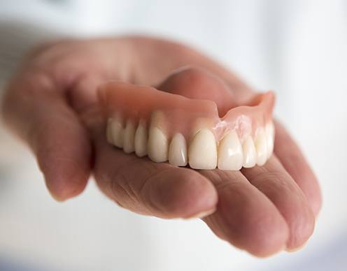 hand holding a full denture