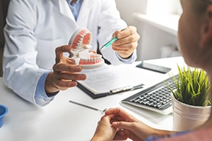 Dentist showing patient model of teeth