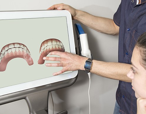 Dentist and patient looking at digital restorations