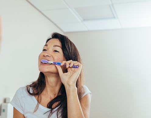 Woman brushing her teeth in bathroom