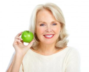 woman smiling holding green apple