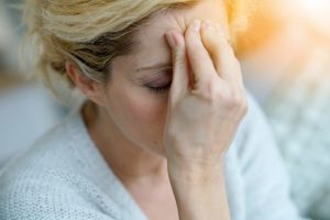 Woman with migraine in Randolph rubbing her forehead