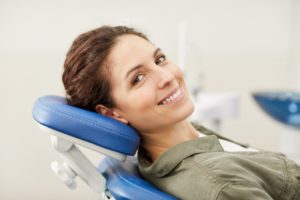 happy female patient visiting dentist, reclining in treatment chair