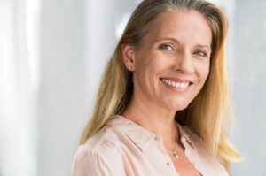 Smiling woman, confident that dental implants are worth the cost