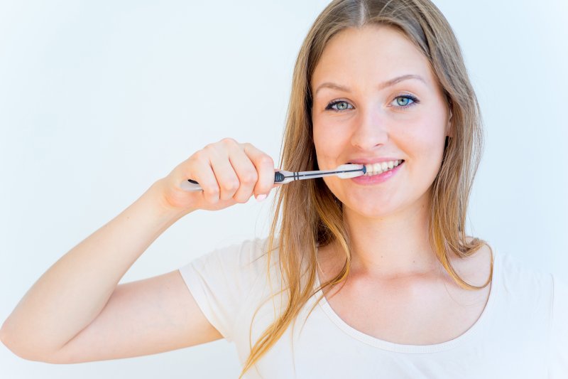 woman brushing teeth to avoid dental emergency in Randolph