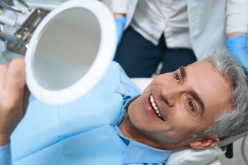 Man looking at work done by cosmetic dentist